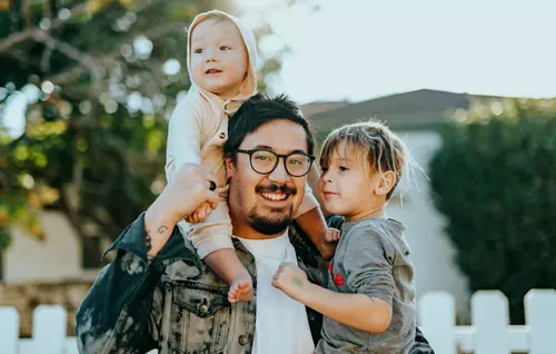 Pappa med två barn utanför villa