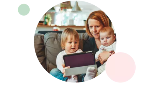 Mamma kollar på en surfplatta med sina två barn