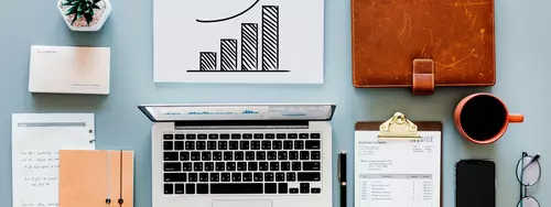 Bord med dator, kaffemugg, anteckningblock