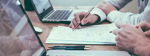 Två personer kollar sin budget på datorerna