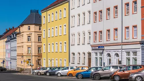 En gata med bostäder och parkerade bilar