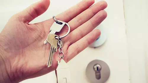 Hand som håller i hemnycklar
